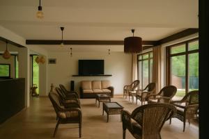 a living room with chairs and a couch and a tv at Cabana Riverdale in Podu Dîmboviţei