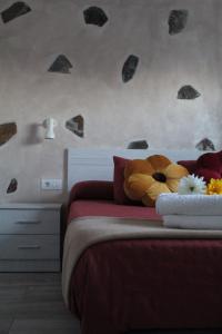 a bedroom with a bed with a red comforter at Casa El Pajar in Breña Alta