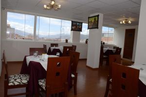a dining room with tables and chairs and large windows at Casa Real Hoteles in Cusco