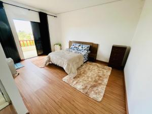 une chambre avec un lit et un parquet dans l'établissement Chalé Vista Linda, à Campos do Jordão