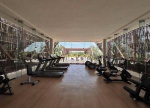 a gym with rows of treadmills and exercise bikes at Penthouse Om in Tulum