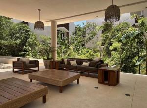 a living room with couches and tables and plants at Penthouse Om in Tulum