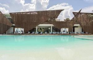 a resort with a swimming pool with blue water at Penthouse Om in Tulum