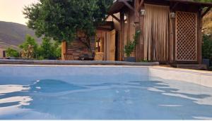 a swimming pool in front of a house at Wooden House at the Mountain-private in Paránimfoi