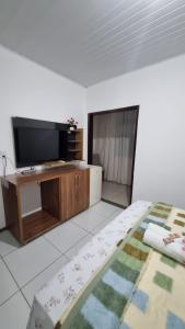 里奥迪孔塔斯Pousada Portal da Chapada的客厅配有平面电视和1张床。