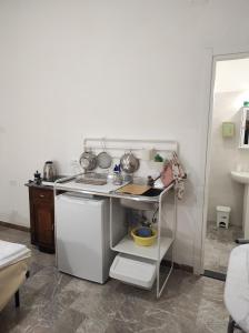 a small kitchen with a table and a sink at La Lenzerina Casa indipendente con giardino in Scarlino +62 photos