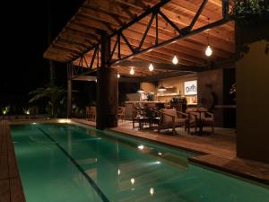 a swimming pool with a patio and a dining area at night at Pandurata Bed and Breakfast in Valle de Bravo +22 photos