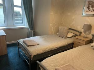 a bedroom with two beds and a window at Budget Rooms in Inverness +38 photos