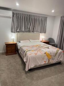 RiverheadにあるBrand-new Family Retreat in Riverhead 4BR Homeの大きなベッドと2つのナイトスタンドを備えた寝室