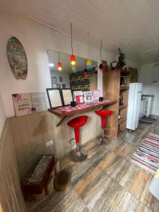 a bar with two red stools in a room at Chale Sabrina in Campos do Jordão