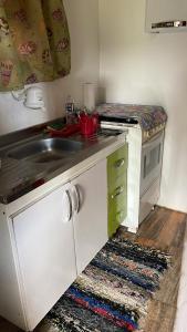 a small kitchen with a sink and a stove at Chale Sabrina in Campos do Jordão