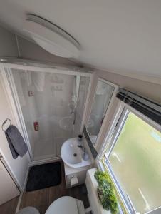a small bathroom with a toilet and a sink at LuKa25 GC080 in Saint Osyth +49 photos