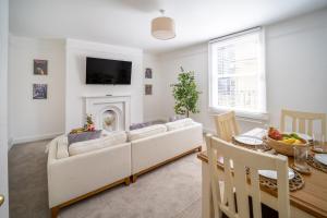 a living room with a couch and a fireplace at Larkhall Retreat- Village Centre, Parking, 4K TVs, 10mins To City Centre in Bath