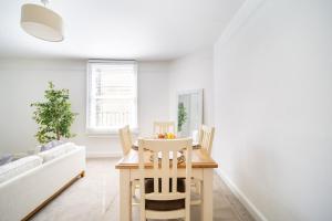 a white living room with a table and chairs at Larkhall Retreat- Village Centre, Parking, 4K TVs, 10mins To City Centre in Bath +14 photos