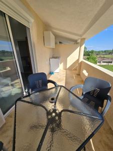 a glass table and two chairs on a balcony at SHARRI Apartments in Ulcinj +26 photos