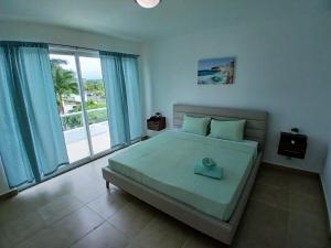 リオ・アトにあるVillas Playa Blanca Terraza con Vista al Marの大きなベッドと大きな窓のある寝室 +33枚の写真
