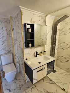 a bathroom with a sink and a toilet at Chaker's Luxury Apartment Fez in Fès +2 photos