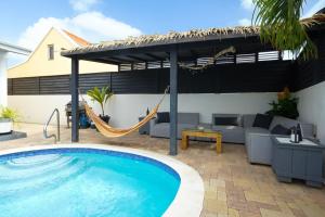 a swimming pool with a hammock and a patio at NEW 3BR 2BA Modern Clean Calbas Villa with Pool in Paraguaná