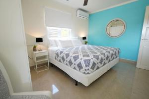 a bedroom with a white bed and a blue wall at NEW 3BR 2BA Modern Clean Calbas Villa with Pool in Paraguaná +19 photos