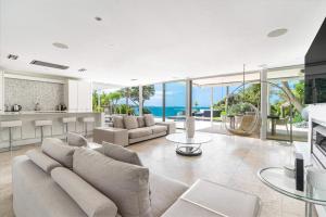 una sala de estar con un sofá y una mesa en Takapuna Clifftop with Pool and Hot Tub, en Auckland