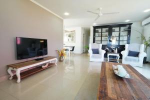 a living room with a flat screen tv and a table at NEW 3BR 2BA Modern Clean Calbas Villa with Pool in Paraguaná