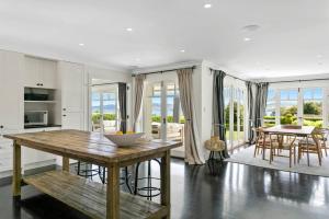 eine Küche und ein Wohnzimmer mit Tisch und Stühlen in der Unterkunft Norfolk House, Luxury Villa With Spa and Lake Views in Taupo