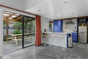 una cucina con armadi blu e un tavolo con sgabelli di Central and Cozy 2BR Retreat With Parking and Free Wifi a Taupo