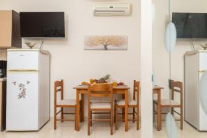 a kitchen with a table and a white refrigerator at Estia cozy apartment in Argostoli