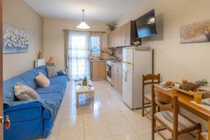 a living room with a blue couch and a kitchen at Estia cozy apartment in Argostoli +25 photos
