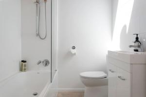 ein weißes Badezimmer mit Dusche und Toilette in der Unterkunft Bellbird Cottage With Lake and Mountain Views in Taupo + 30 Fotos