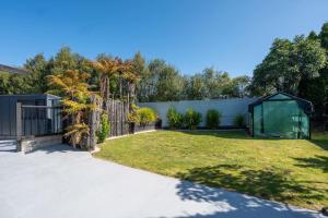 un cortile con una recinzione e una serra di Te Aroha Whare, Cozy 3BR Retreat With Garage and BBQ a Taupo