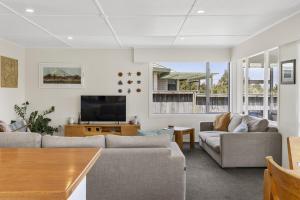 a living room with two couches and a flat screen tv at Fantail Retreat, Family 4BR Near Lake and Gardens in Taupo