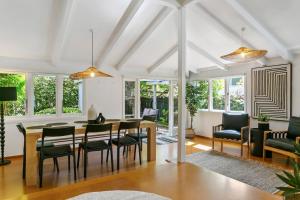 a dining room and living room with a table and chairs at Huia Haven, Rustic Garden Retreat With King Suite in Taupo