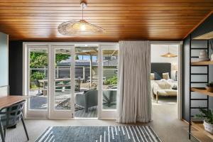 a living room with sliding glass doors leading to a patio at Huia Haven, Rustic Garden Retreat With King Suite in Taupo