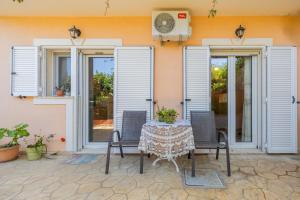 a patio with a table and chairs in front of a house at Estia cozy apartment in Argostoli