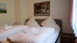 two beds in a room with white sheets and pillows at "Allgäuglück", Oberstaufen in Oberstaufen