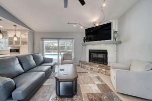 a living room with a couch and a fireplace at Lighthouse Retreat With A Pool in Ponce Inlet