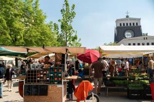 people walking around a market with a clock tower in the background at Apartment in Prague's Best Local Area in Prague