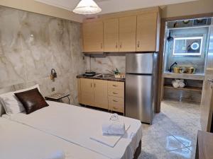 a kitchen with a bed and a stainless steel refrigerator at Sammys apartments in Nea Potidaea