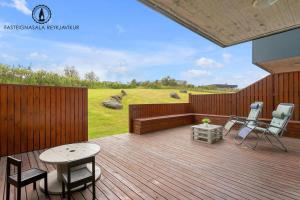 a wooden deck with a bench and chairs on it at Dream Apartment in Reykjavík +1 photo