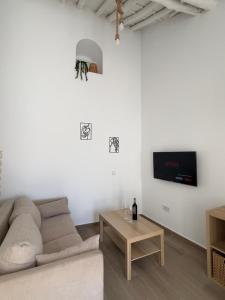 een woonkamer met een bank en een tv bij Casa Peñas 2 in Ronda