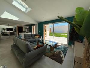 a living room with a couch and a table at Villa Karasse in Lège-Cap-Ferret
