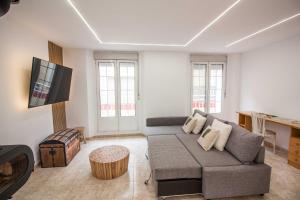 a living room with a couch and a flat screen tv at Casa Menta in Bañeres de Mariola