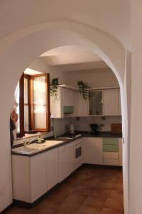 a kitchen with white cabinets and an archway at A BeautifuL Terrace on Paradise Imperia - by HOST4U in Montegrazie