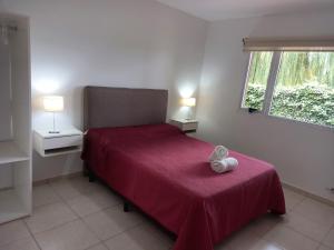 a bedroom with a red bed and a window at Departamentos Capernaum in Santa Rosa