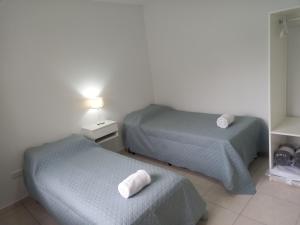 two beds in a hotel room with towels on them at Departamentos Capernaum in Santa Rosa