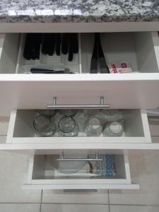 a white cabinet with some dishes in it at Departamentos Capernaum in Santa Rosa