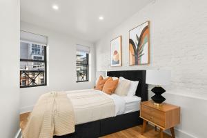 een witte slaapkamer met een bed en twee ramen bij Prime NYC Location 4BR Spacious Haven in New York