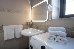 a bathroom with a sink and a mirror and towels at Quirin's Apartments in Taormina +44 photos