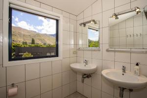 a bathroom with two sinks and a window at Wanaka Retreat Spa, Sauna & Mountain Views in Wanaka +40 photos